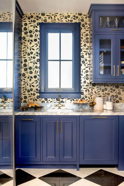 bathroom design with blue cabinets and wallpaper